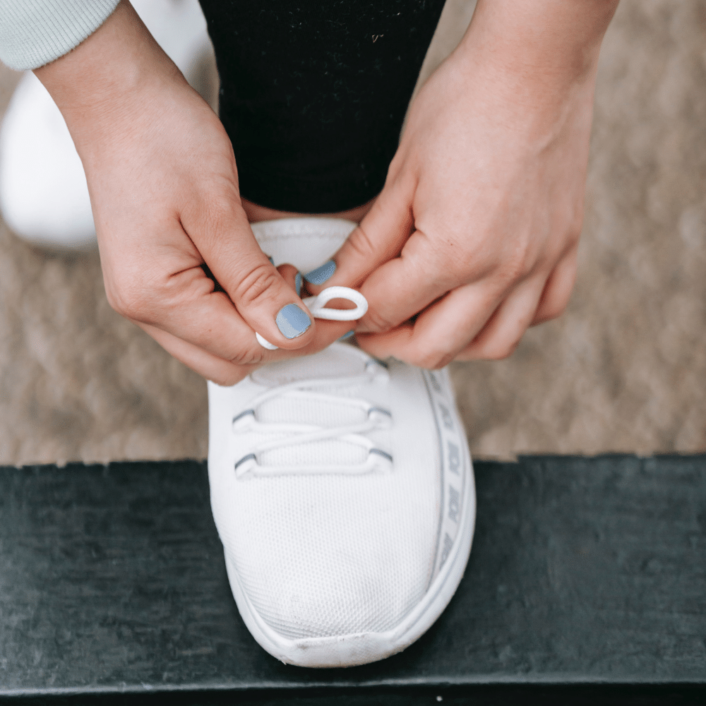  Photo of person tieing their shoe Photo by Andres Ayrton