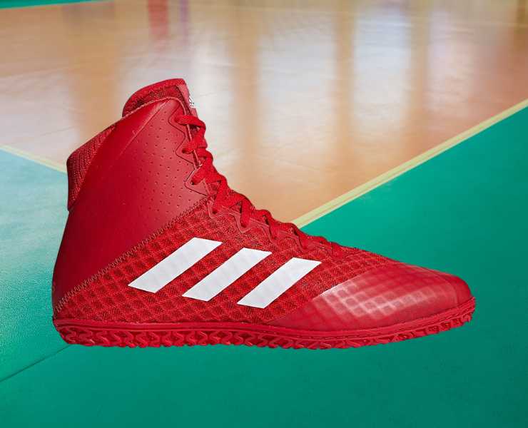 Side view of adidas Men's Mat Wizard 4 Wrestling Shoe on a gym floor